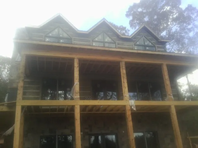 Dormers and porch framing on a large log home under construction — Roof Coating work by our crew in West Chester
