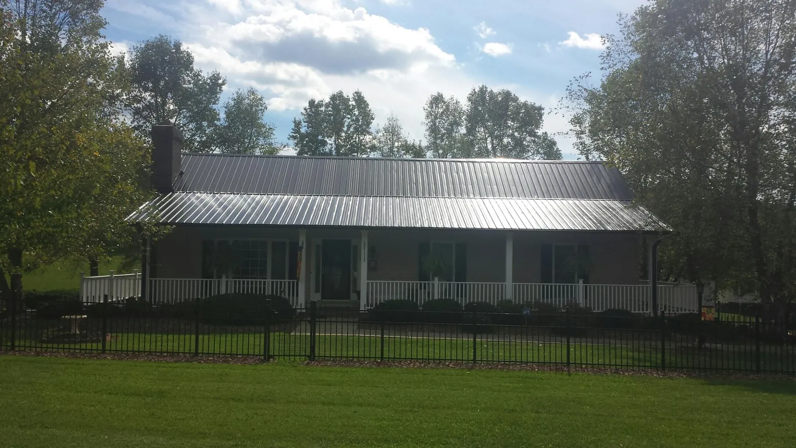 Gray metal roof on a brick ranch with a full width front porch — Gutter Guard Installation work by our crew in West Chester