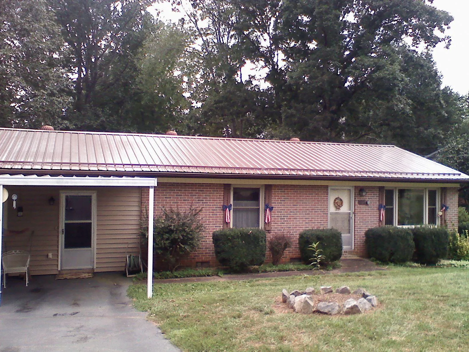 Bronze metal roof and carport on a brick ranch home — Roof Repair work by our crew in West Chester